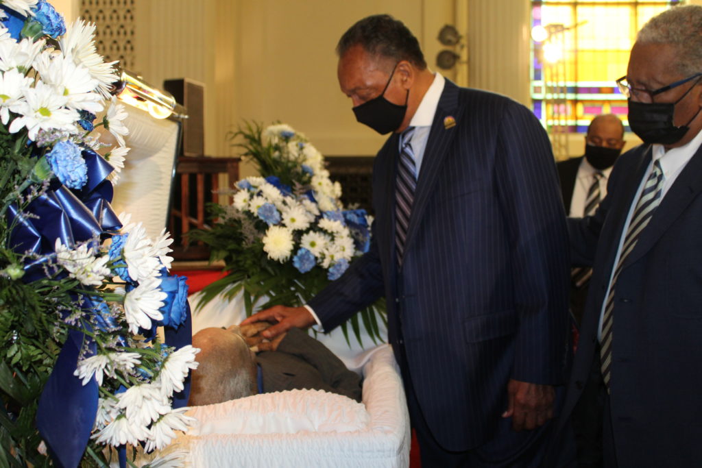 REV. JACKSON TOUCHING THE HANDS OF ST. CLAIR BOOKER g