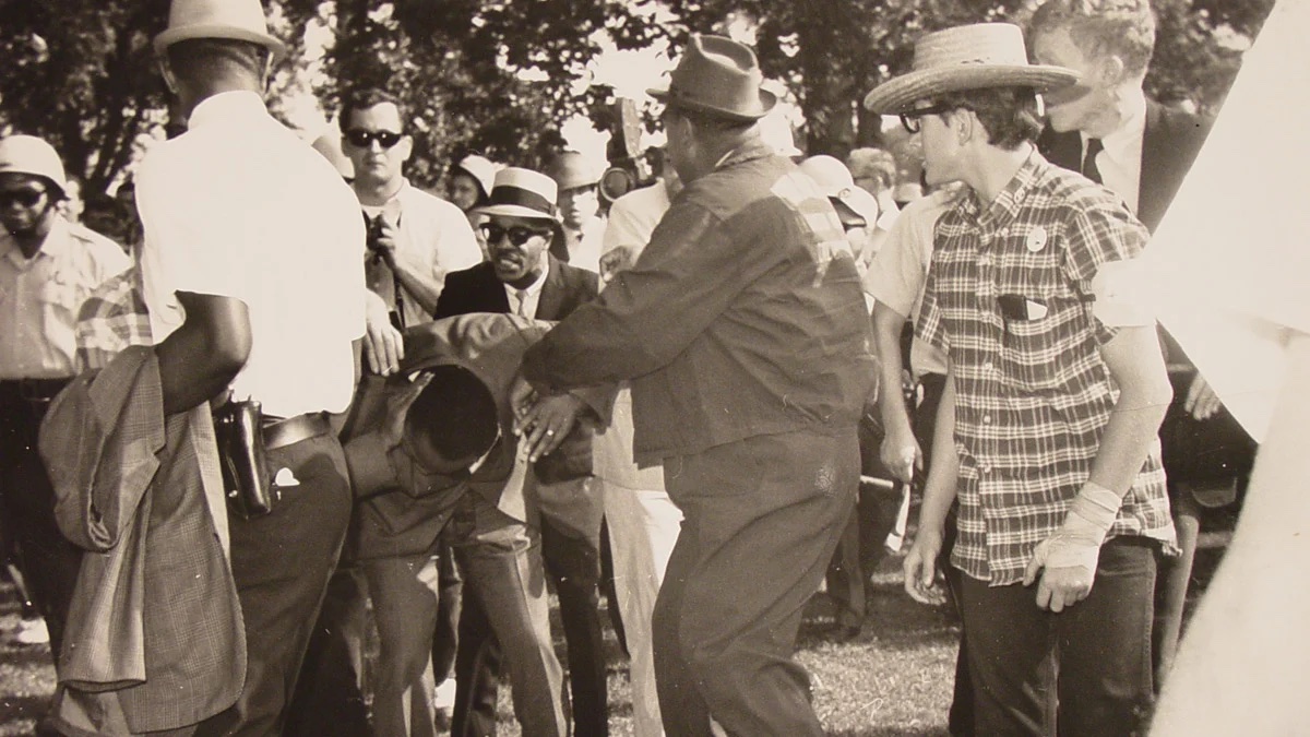  MARTIN LUTHER KING JR. is bent over after being hit in the head with a rock during a Chicago march in 1966.