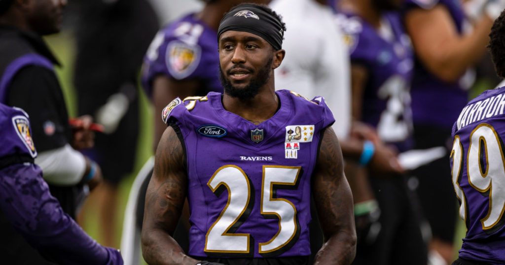 Tavon Young standing on the field in his Baltimore Ravens uniform
