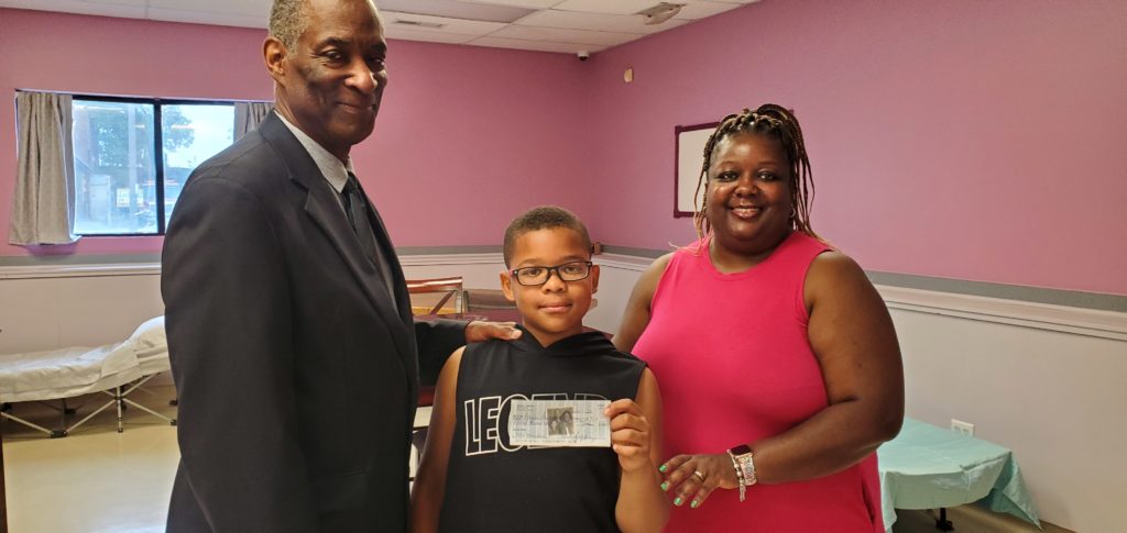 8-YEAR-OLD Darnell Gaffney, Jr. (center) accompanied by his mother, Alisha (right) presenting a $1,000 check to Grace Beyond Borders Executive Director Marcus Martin.