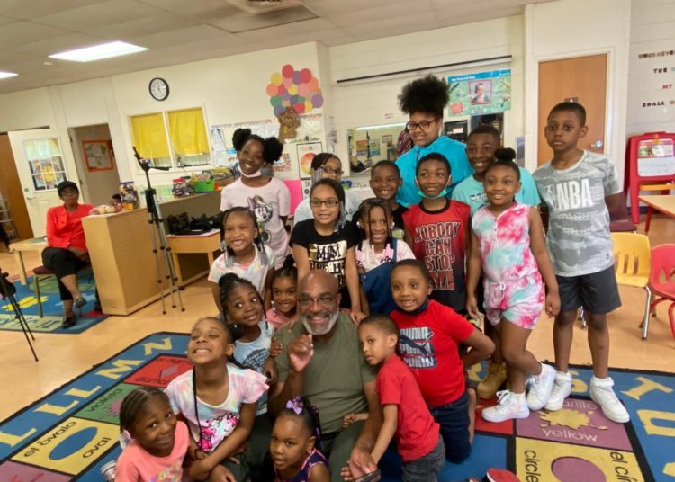 Actor/Comedian Buddy Lewis posing with a group of children after his “Books with Buddy” event