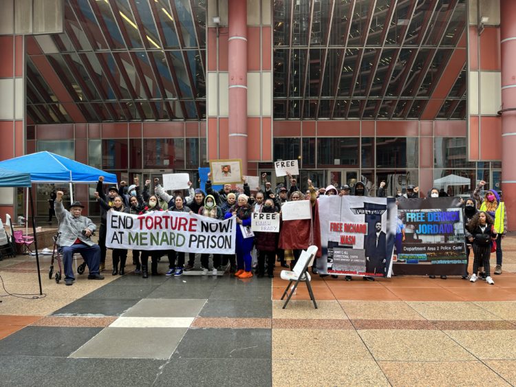 FRANK CHAPMAN (seated, far left), joined by other activists and protestors led a rally on March 23, 2022, to end the torture in Menard Prison. The rally was held at the Thompson Center/State of Illinois Building in Chicago’s downtown. (Photo by Chinta Strausberg)