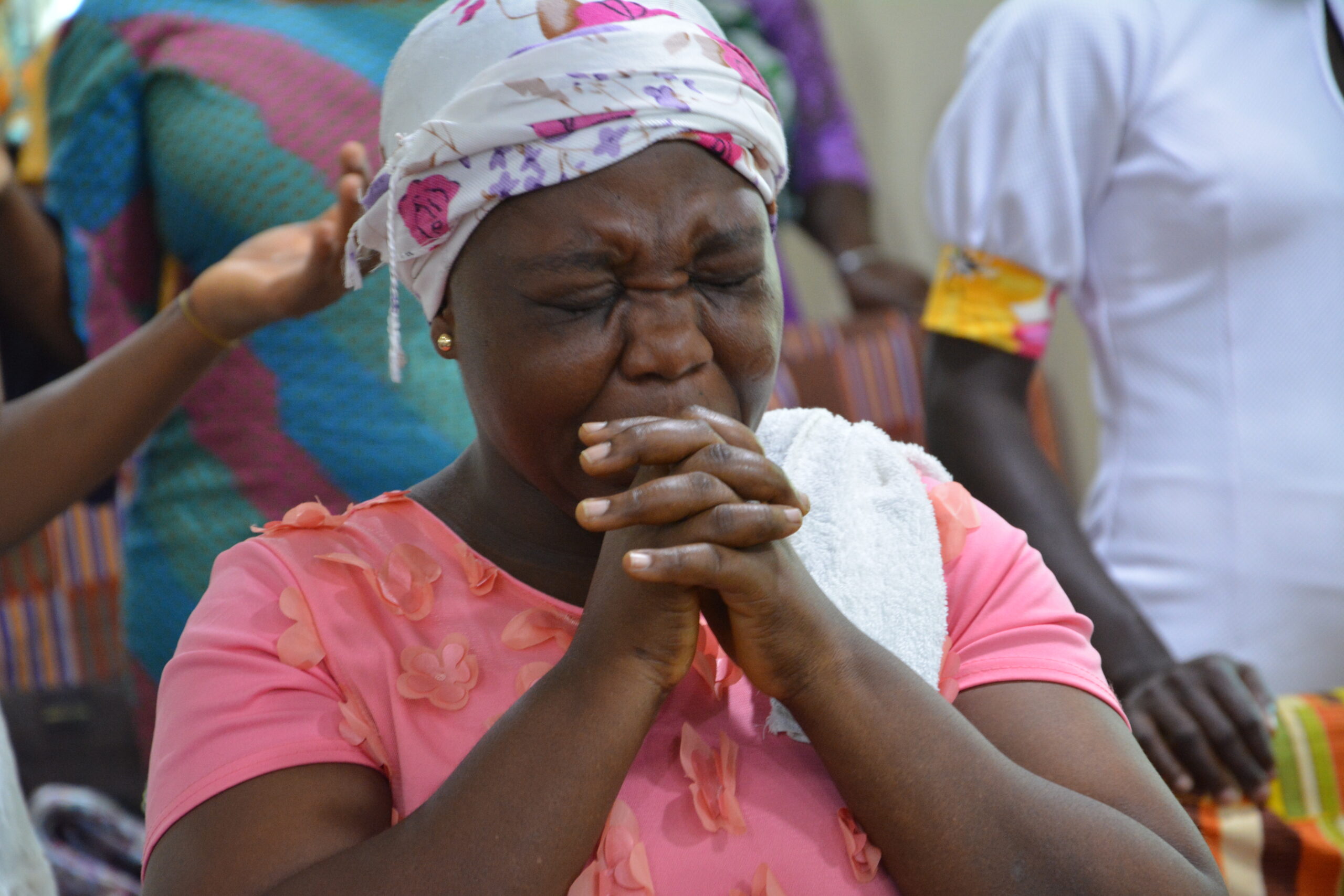 A WOMAN AT a church in the Greater Accra region of Ghana clasps her hands with her eyes shut tight in prayer during a Sunday praise and worship service.