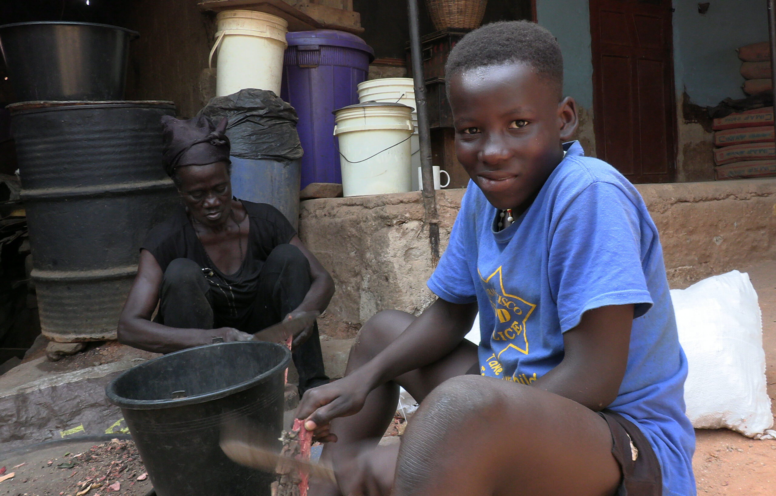 A LITTLE BOY in Kumasi helps with the family Adinkra cloth business by cutting tree bark used to create dye.