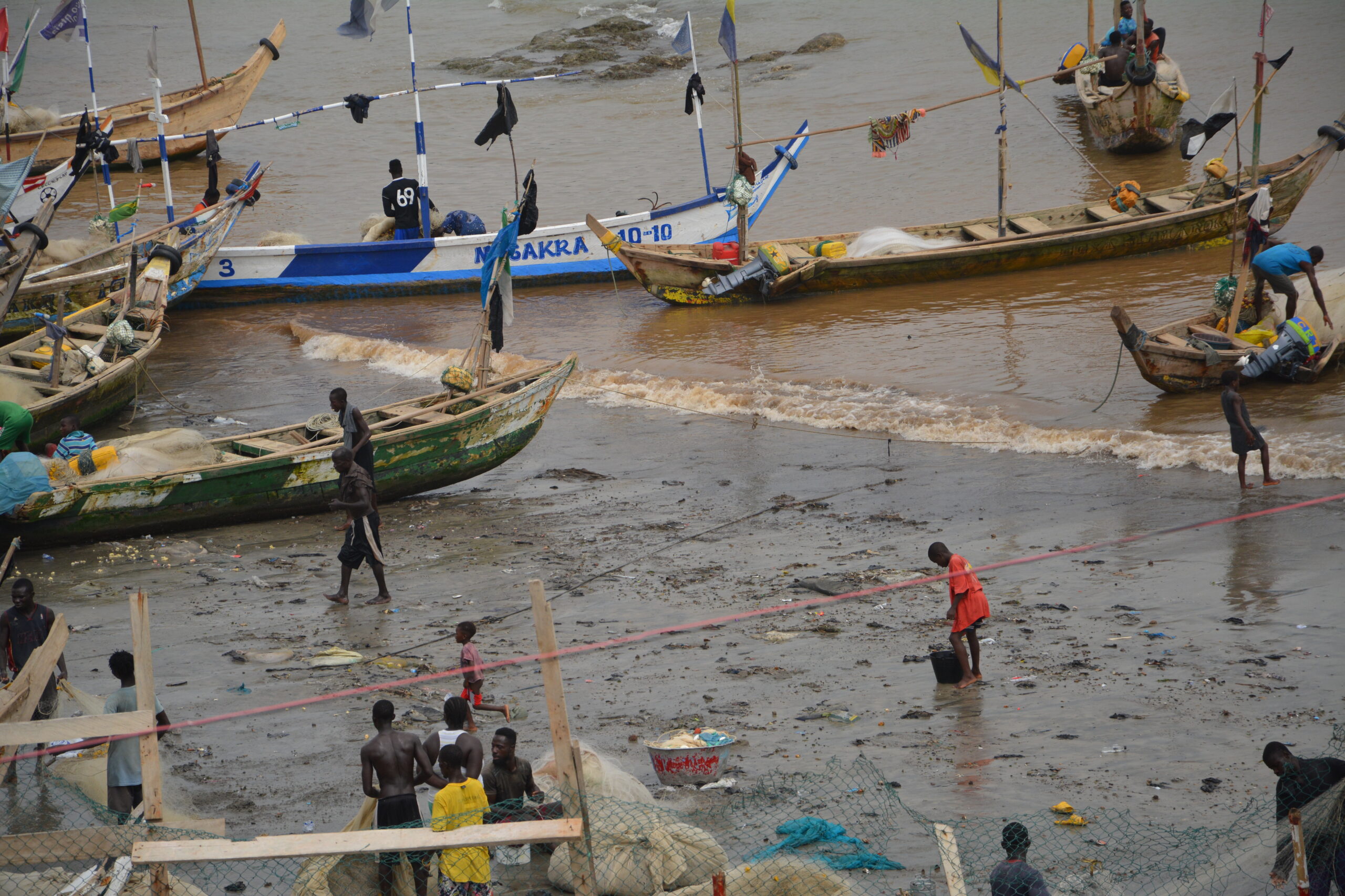 BENEATH A SLAVE castle at the edge of the Atlantic Ocean, Ghanaian fishermen are hard at work.
