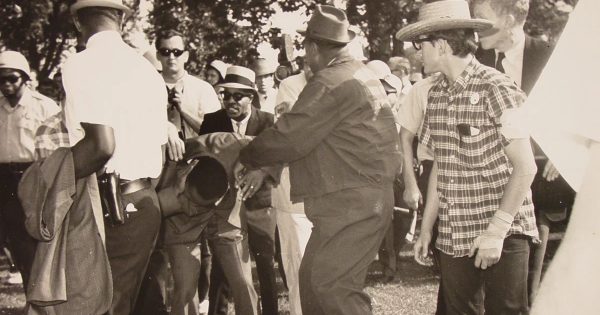 MARTIN LUTHER KING JR. is bent over after being hit in the head with a rock during a Chicago march in 1966.
